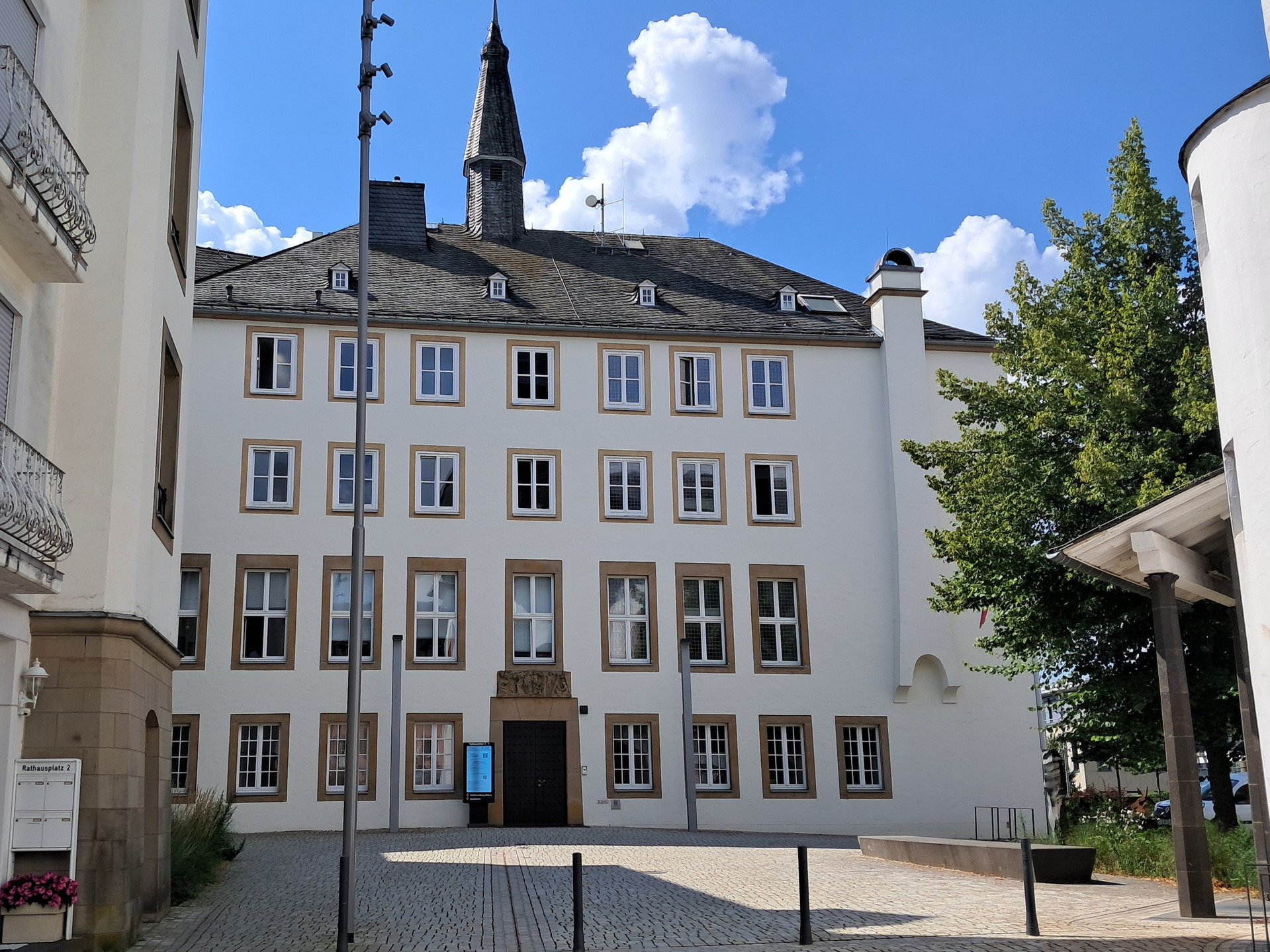 Zu sehen ist ein renoviertes Gebäude mit einen Turm und vielen Fenstern.